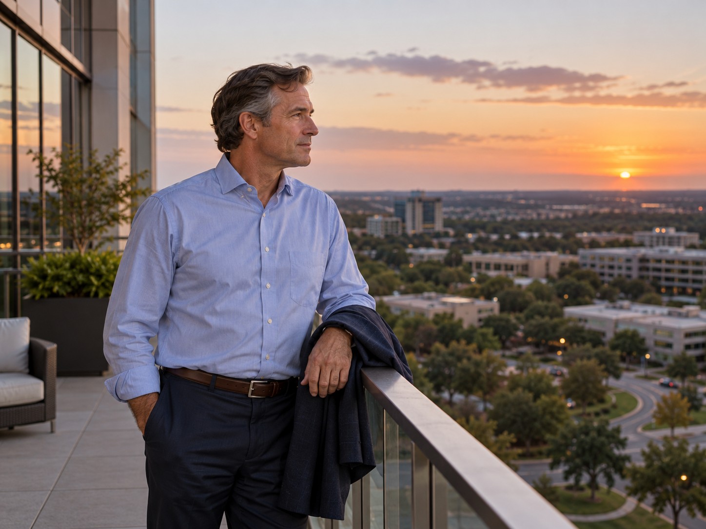 A long-tenured employee on an office balcony at dusk.